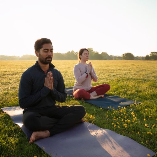 side-view-man-woman-meditating-outdoors